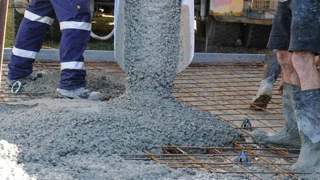 Concreters guiding a pour over steel reinforcement