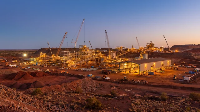 A minesite plant under construction lit up at dusk