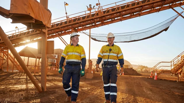 Two workers sharing a laugh walking through a minesite