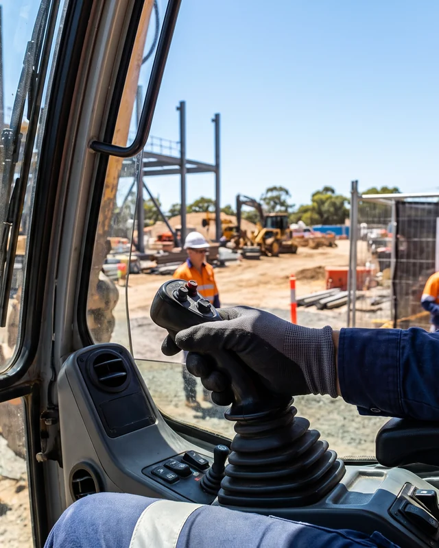 An operator at the controls of an excavator on site