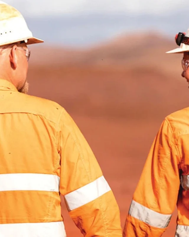 Two workers in hi-vis walking a site together